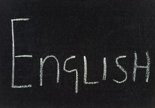The word English written in chalk on a black board.