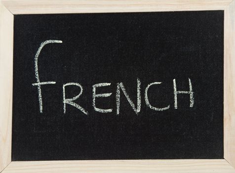 A black board with a wooden frame and the word 'FRENCH' written in chalk.