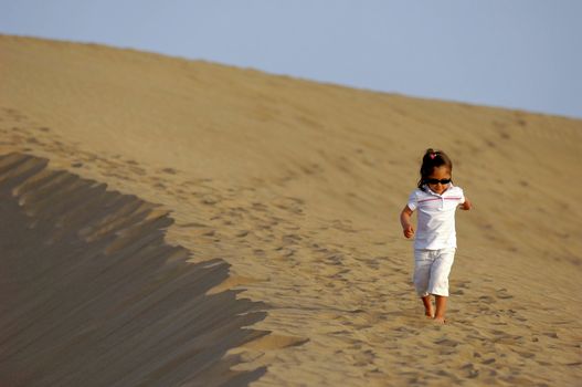 A child is walking alone in the desert