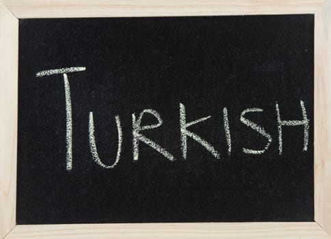 A black board with a wooden frame and the word 'TURKISH' written in chalk.