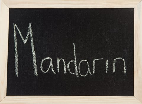 A black board with a wooden frame and the word 'MANDARIN' written in chalk.