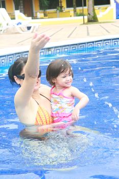 Mother and baby playing in a swimming pool