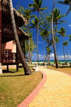 Luxury hotel at tropical resort on ocean shore with palm trees