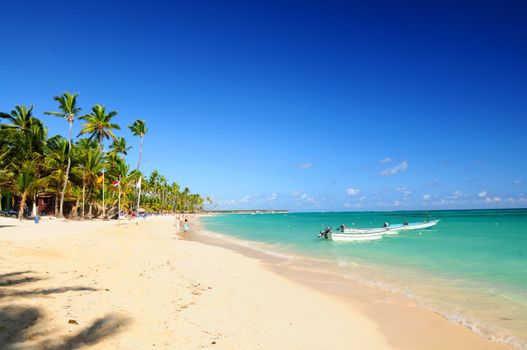 Sandy beach on Caribbean resort and fishing boats at sea