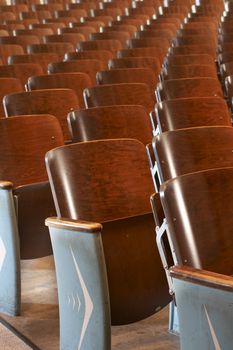 rows of wood chairs in an old auditorium