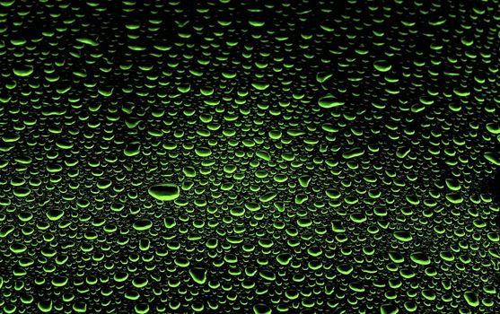 an abstract picture of green water drops on black