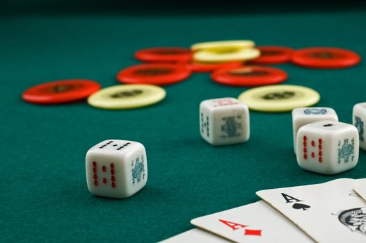 Dice, cards and chips on green carpet with selective focus