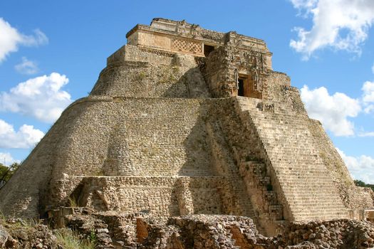 Uxmal main pyramid over blue sky with clouds
