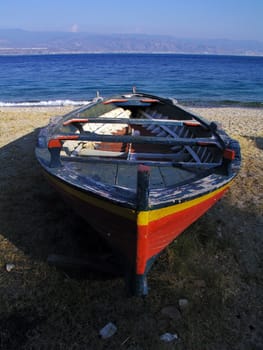 Boat resting ashore with sea in the background