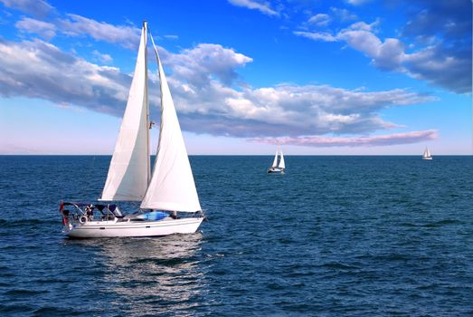 Sailboat sailing in the morning with blue cloudy sky