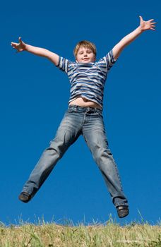 A little boy jumps with sky at background