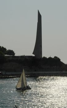 Sailboat with monument, similar to the sail at background.
