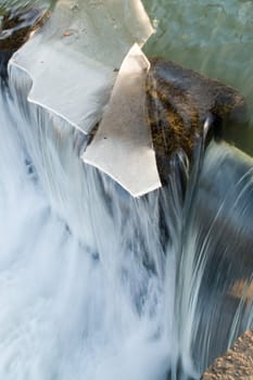 Floating of ice on the river. Small waterfall. Ice floe now will fall.