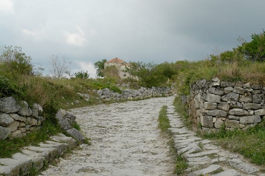 Paved road in the mountains with cloud sky at background