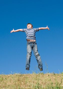 A little boy jumps with sky at background