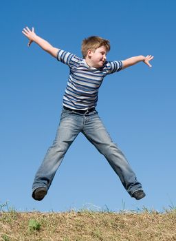 A little boy jumps with sky at background