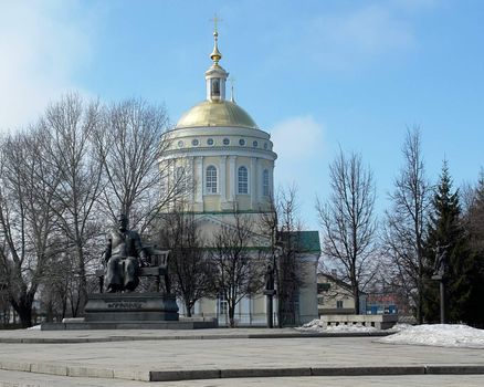 Monument to great Russian writer Leskov against the background of orthodox church in Orel, Russia