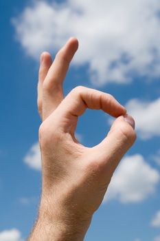 hand with symbol ok with sky at background