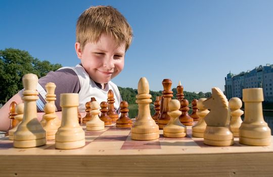 A little boy chess with sky at background