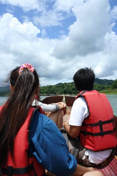 Woman and man sit on boat at river