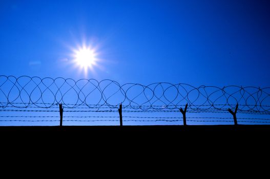 Fence with a barbed wire and blue sky