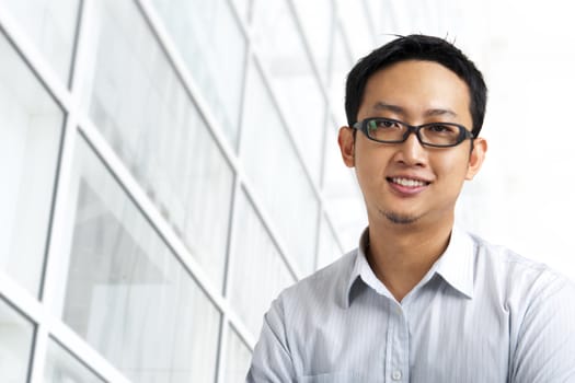 Good looking Asian standing outside office building