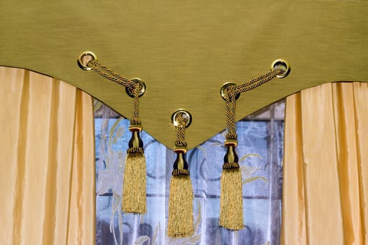 window with tulle and decorated with tasselled curtains