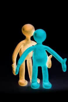 Two shaded plasticine puppets standing on black background