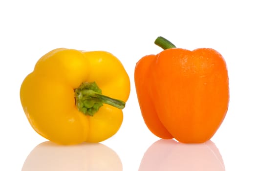 Two peppers on white reflective background.