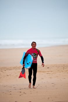 SAN FERNANDO, CADIZ, SPAIN - FEB 19: Unknown bodyboader going to the water on the 2nd championship of Surf and BodyBoard Impoxibol on Feb 19,2011 on the beach of Camposoto of San Fernando, Cadiz, Spain
