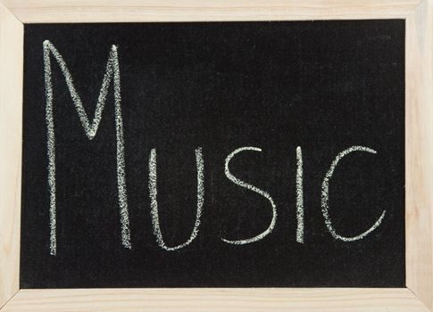 A black board with a wooden frame and the word 'MUSIC' written in chalk.