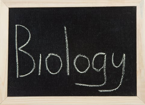 A black board with a wooden frame and the word 'BIOLOGY' written in chalk.