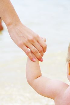 Baby hand holding mother finger isolated on white