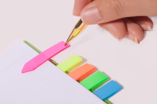 Female hand writing bookmark on notebook