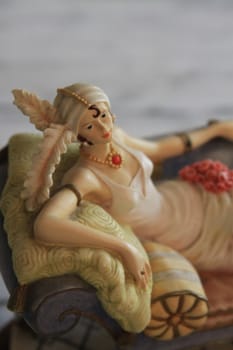 Antique figurine close up over background.