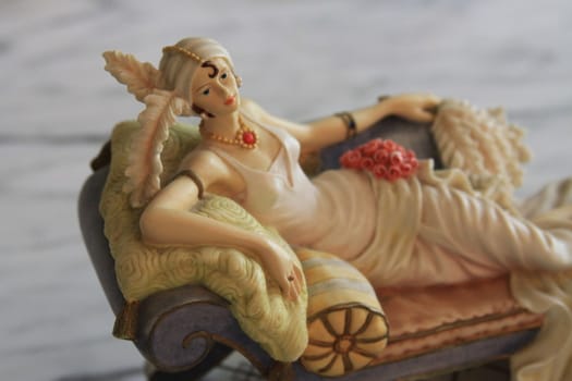 Antique figurine close up over background.