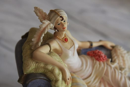 Antique figurine close up over background.