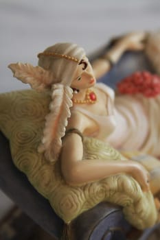 Antique figurine close up over background.