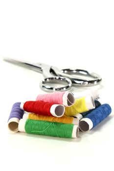 colorful spools of thread and sewing on a white background