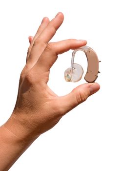 A woman's hand  holding a digital hearing aid  with ear mould and tubing between her fingers. Isolated on white.
