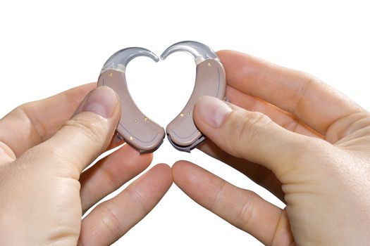 Hands showing a heart shape from digital hearing aids. Isolated on white.