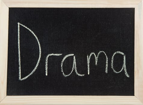 A black board with a wooden frame and the word 'DRAMA' written in chalk.