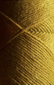 Close-up of a skein of gold wool knitting yarn