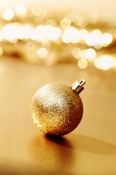 golden christmas ball on golden star bokeh background