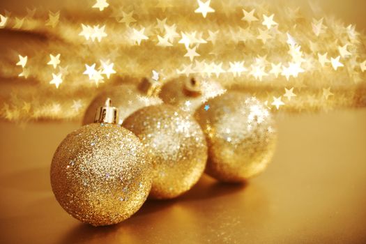 golden christmas ball on golden star bokeh background