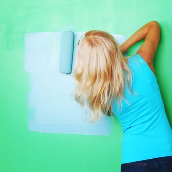 woman paints the wall roller