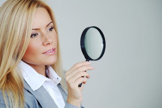 business woman looking through a magnifying glass