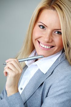 business woman on gray background  pen in hands