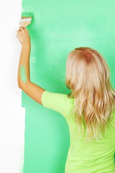 woman paints the wall brush