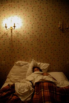 Woman sleeping in an old bedroom hotel in France